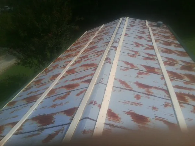 Rusted metal roof panels with new wood purlins before replacement — Storm Damage Roof Repair in Mount Sinai by Roofing Brothers