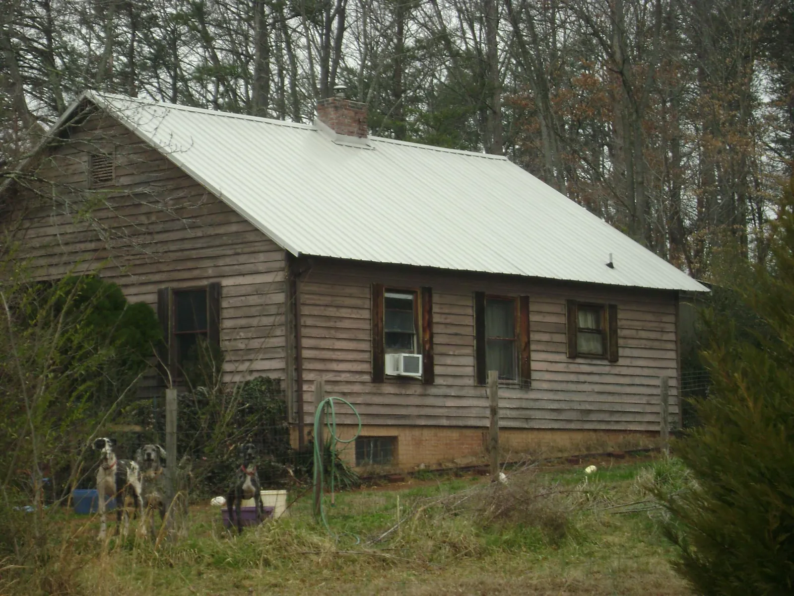 White metal roof on an old wood sided farmhouse, from a Metal Roof Installation job in Mount Sinai